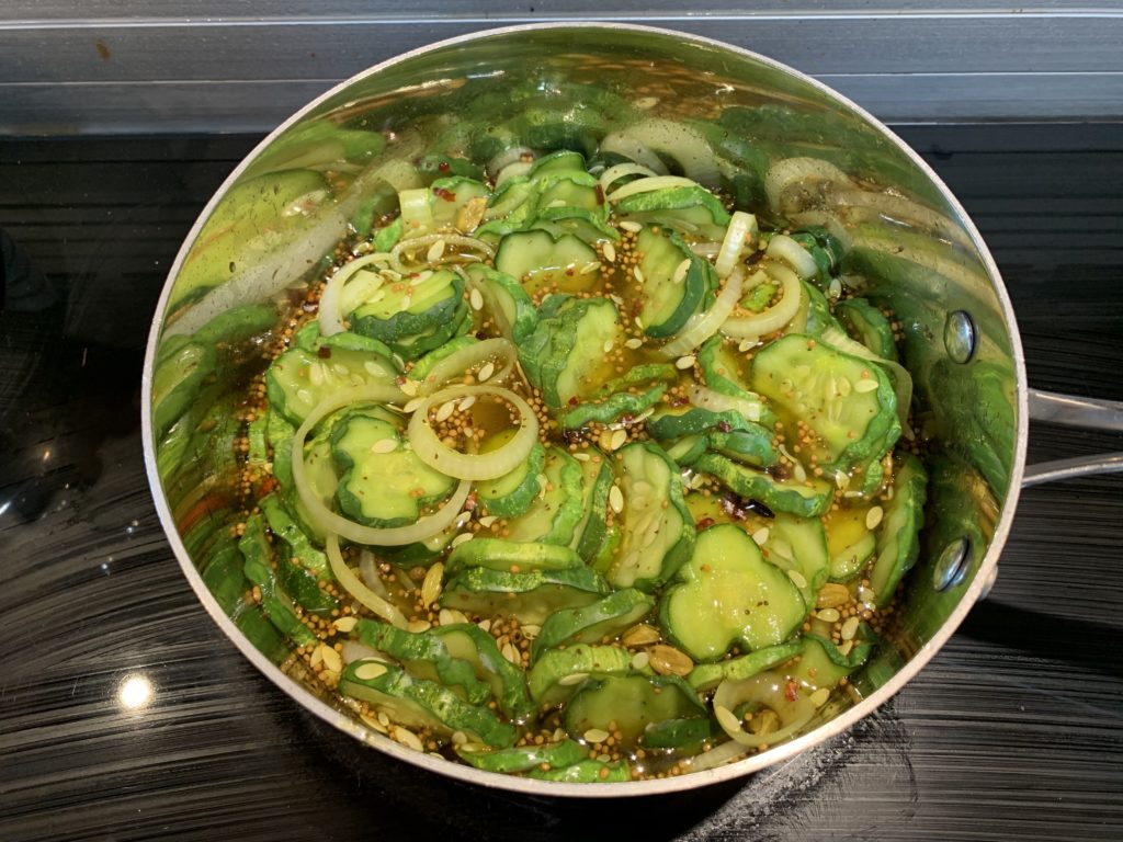 Gherkins and onions simmering in the pickling syrup.